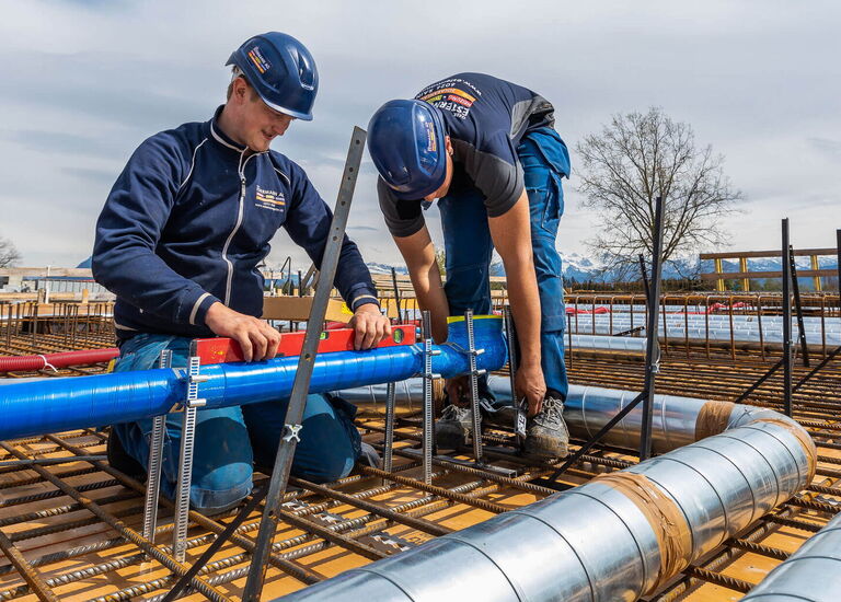 3 Handwerker beim Messen und Montieren auf einer Baustelle