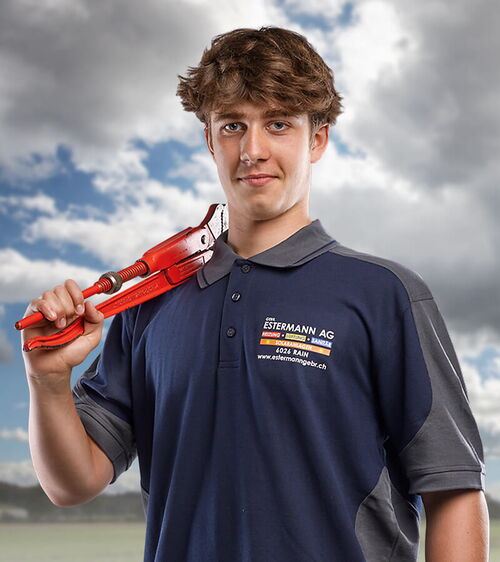 Sandro Hofmann Junger Handwerker mit roter Wasserpumpenzange vor Wolkenhimmel