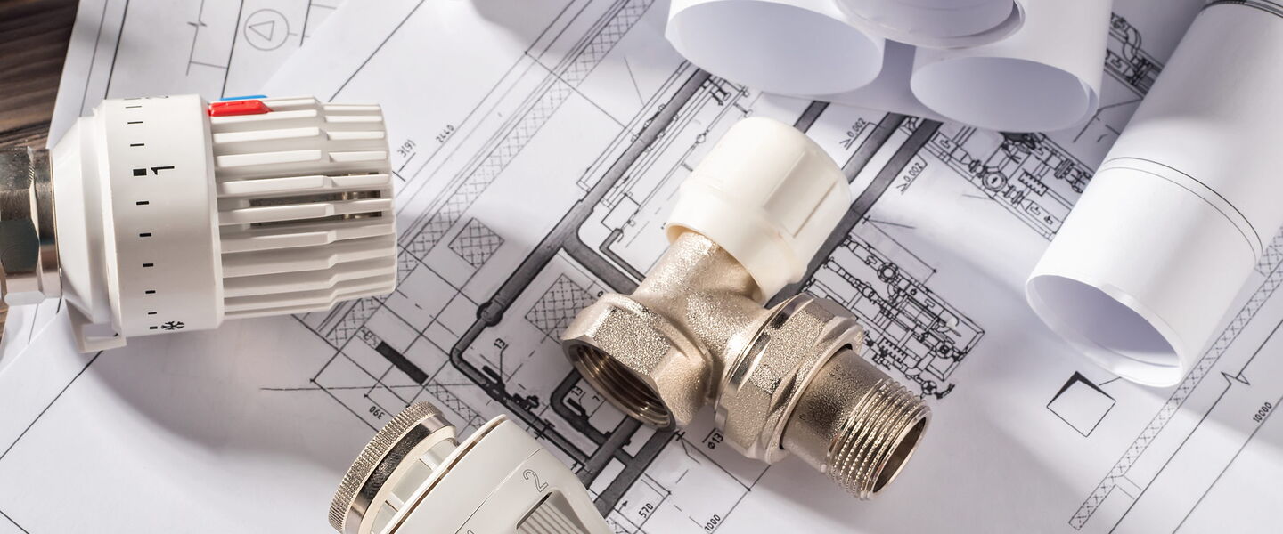 Technischer Bauplan und Heizujngsventile die auf technischen Zeichnungen liegen
